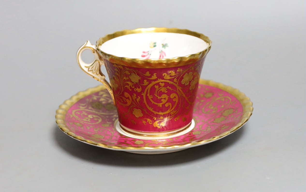 A Chamberlains Worcester superb coffee cup and saucer with crinson ground and elaborate gilding the saucer painted with flowers, the cup painted with flowers in and out, script mark in red to cup